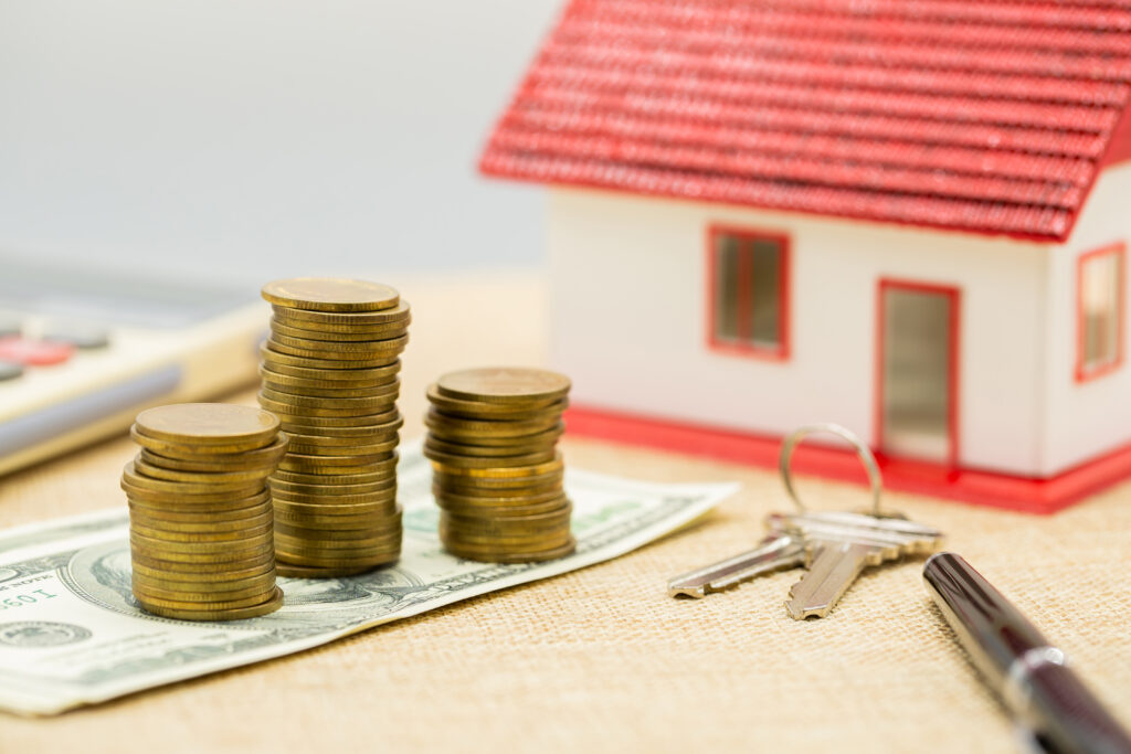 House placed on coins. notebook and pen Prepare planning savings money of coins to buy a home concept.